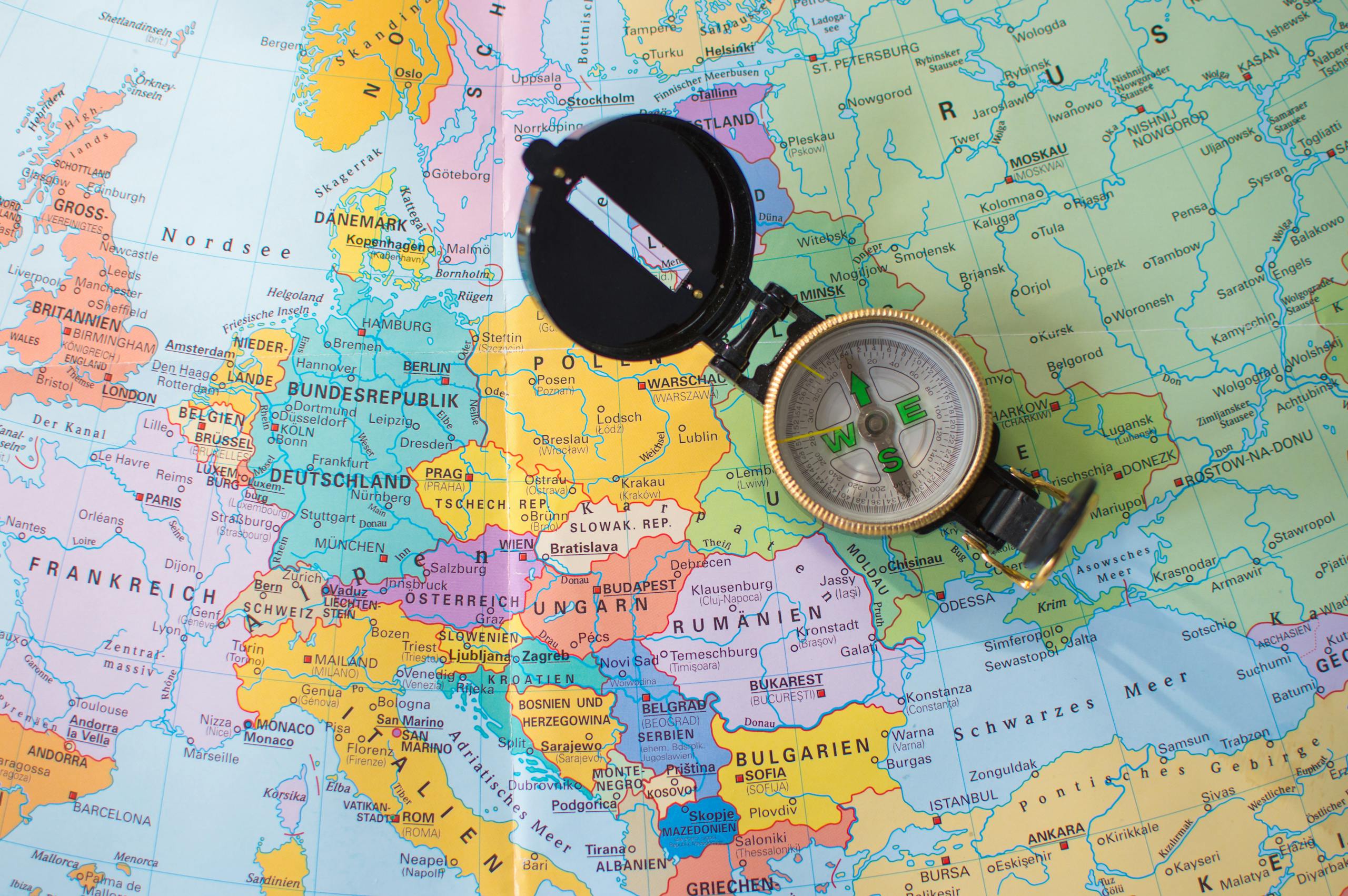 A flat lay image of a compass on a map of Europe, symbolizing travel and direction planning.